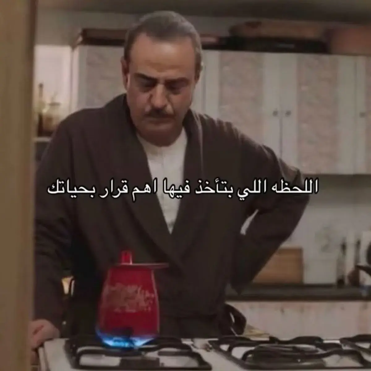 رجل بروب منزلي يقف أمام الموقد يحضّر القهوة بتركيز